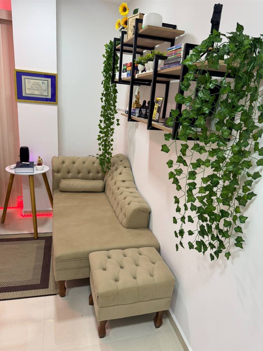 Sala de espera aconchegante do consultório, com sofá e decoração acolhedora